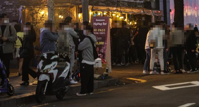 회적 거리두기가 1단계로 완화된 지난달 16일 밤 서울 마포구 홍대축제거리 인근 클럽, 포차 밀집 지역에서 젊은이들이 클럽과 포차 앞에서 입장을 기다리고 있다. 연합뉴스