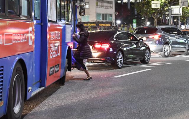 지난달 27일 오후 7시쯤 서울 서대문구 경찰청 인근 정류장에서 한 시민이 버스정류장 인근을 한참 벗어나 정차한 시내버스를 타기 위해 도로 위를 걸어가고 있다.