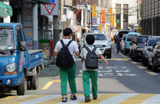 학생들이 인도와 차도가 구분되지 않은 위험한 도로로 하교하고 있다. 한국일보 자료사진