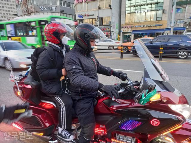 3일 서울 종로구 경복궁역 3번 출구 앞에서 한 수험생이 모터사이클 동호회 회원의 오토바이에 탑승하고 있다. 최다원 기자