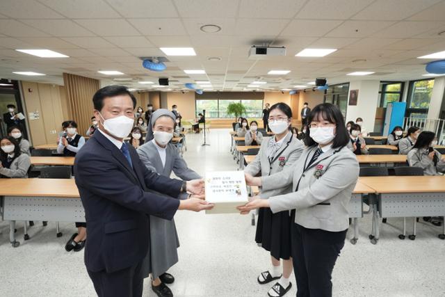 서울 성북구 계성고에 재학중인 나유정(오른쪽 뒤)ㆍ진영주(오른쪽 앞)양이 서울 성북구 소재 학교에서 이승로 성북구청장에게 철거될 뻔한 독일 베를린 미테구 평화의 소녀상을 지켜준 독일 주민에게 쓴 감사 편지들을 편지함에 담아 전달하고 있다. 성북구 제공