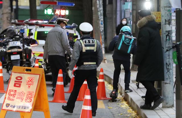 11월 27일 저녁 서울 마포구 서교동 일대에서 경찰들이 음주 단속을 실시하고 있는 가운데 전동킥보드를 탄 배달원이 음주단속을 피하려다 적발당하고 있다. 뉴스1