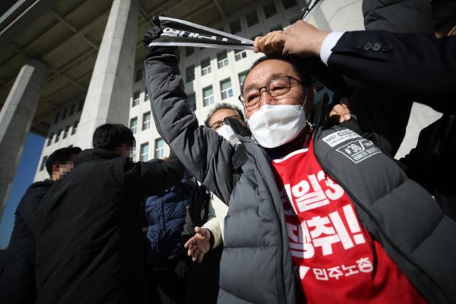 김재하 민주노총 비상대책위원회 위원장이 8일 오전 서울 국회 본관 앞 계단에서 정부의 노조법 개정안을 규탄하는 기자회견을 하다 관계자들의 제지를 받고 있다. 연합뉴스