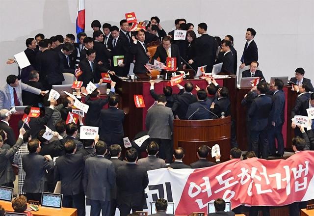 2019년12월 27일 국회 본회의장에서 자유한국당 의원들이 의장석에 몰려와 항의를 하는 동안 문희상 국회의장이 '공직선거법 개정안'을 가결 선언하며 의사봉을 치고 있다. 오대근기자