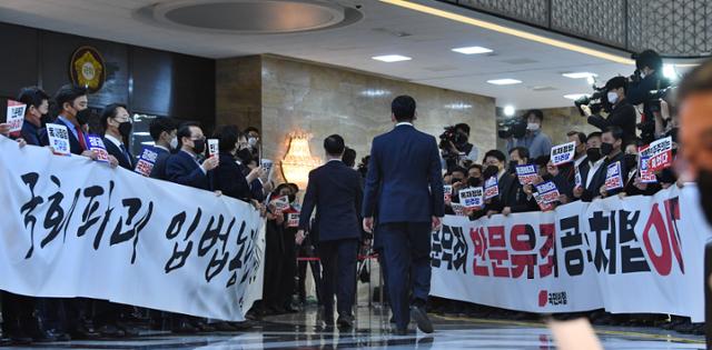 국민의힘 의원들이 10일 국회 본회의장 입구에서 입장하는 더불어민주당 의원들을 향해 '위선정권 막장정치 민주당에 경고한다' 등의 구호를 외치고 있다. 오대근 기자