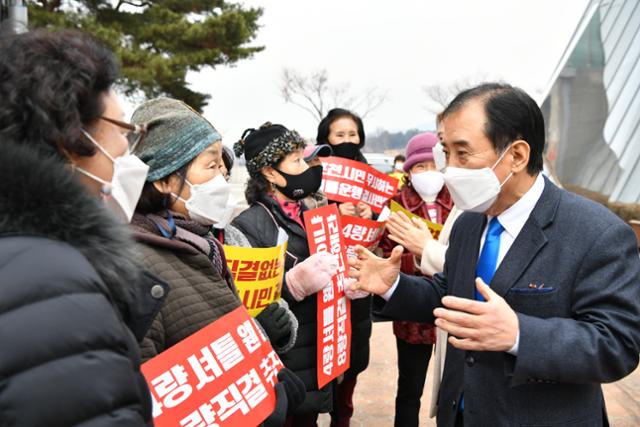 박윤국(오른쪽) 포천시장이 10일 전철 7호선 옥정~포천 연장사업 기본계획 주민 설명회장 앞에서 전동차 4량 운행 계획에 반발해 피켓 시위를 벌이는 주민들과 이야기를 나누고 있다. 포천시 제공