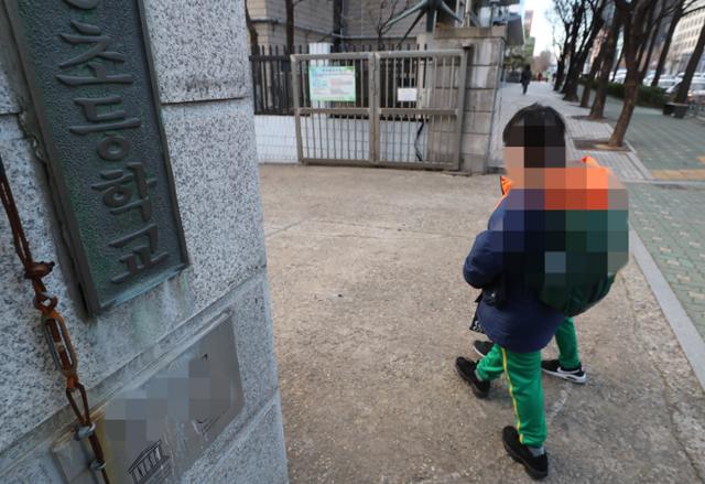 8일 서울 한 초등학교에서 학생들이 등교하고 있다. 코로나19 일일 신규 확진자가 1,000명을 넘어선 13일 서울시교육청은 중·고등학교에 이어 유치원과 초등학교까지 전면 원격수업을 실시하기로 결정했다. 연합뉴스