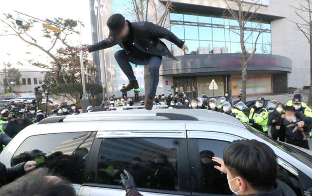 형기를 마치고 출소한 아동 성범죄자 조두순이 탑승한 관용차량이 12일 오전 경기도 안산시 법무부안산준법지원센터에서 나오던 중 일부 시민과 유튜버 등에 가로막혀 있다. 연합뉴스