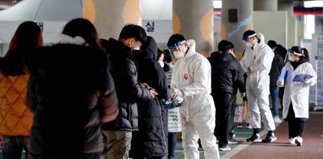 13일 오후 경기 부천종합운동장에 마련된 선별진료소 앞에 검사를 받으로 온 시민들이 길게 줄을 서 대기하고 있다. 뉴시스