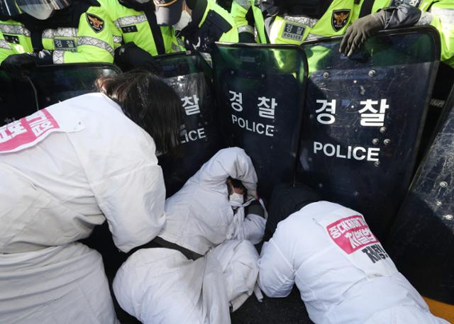 중대재해기업처벌법 제정을 촉구하며 오체투지 중인 비정규직 '이제그만 공동투쟁' 관계자들이 14일 오후 서울 여의도 국회 인근에서 해산을 요구하는 경찰과 충돌하고 있다. 뉴스1