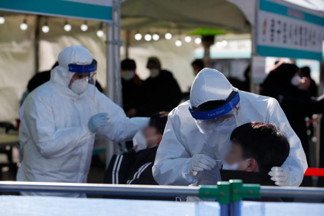 16일 오전 서울 중구 서울역광장에 마련된 코로나19 임시 선별진료소에서 의료진이 검체 채취를 하고 있다. 뉴스1