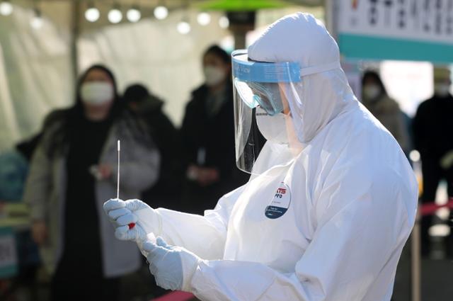 17일 오후 서울 중구 서울역광장에 마련된 임시 선별진료소에서 의료진이 시민들의 검체를 채취하고 있는 모습. 뉴시스