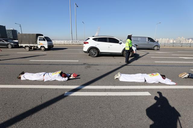 17일 오후 서울 마포대교에서 35년 전 한진중공업에서 해고된 김진숙 민주노총 부산본부 지도위원의 복직을 촉구하는 시민사회단체가 오체투지를 하고 있다. 연합뉴스