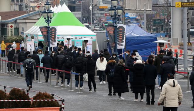 18일 오전 서울 중구 서울역광장에 마련된 코로나19 임시 선별진료소에서 시민들이 검사를 위해 줄 서 있다. 뉴스1