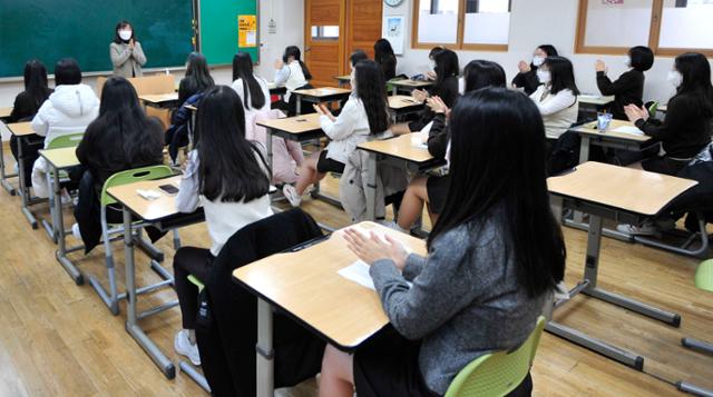 23일 서울 한 고등학교 학생들이 대학수학능력시험 성적표를 받은 뒤 서로에게 격려의 박수를 치고 있다. 사진공동취재단