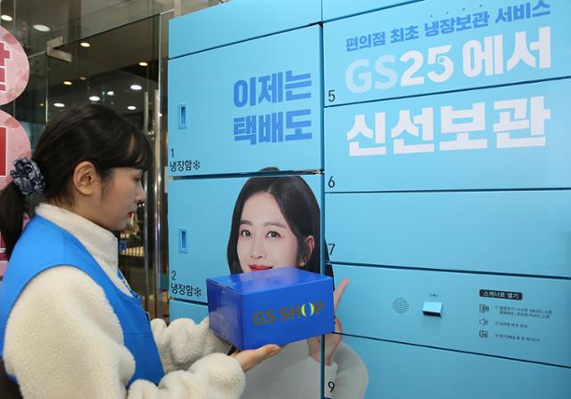 GS25에 설치돼 있는 무인 택배함에서 직원이 GS샵 배송 물건을 꺼내고 있다. GS25 제공