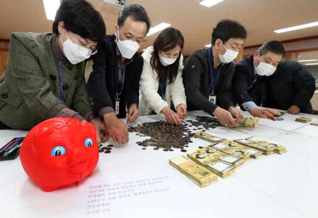 29일 전북 전주시 노송동주민센터 직원들이 '얼굴 없는 천사'가 놓고간 성금을 헤아리고 있다. 전주시 제공