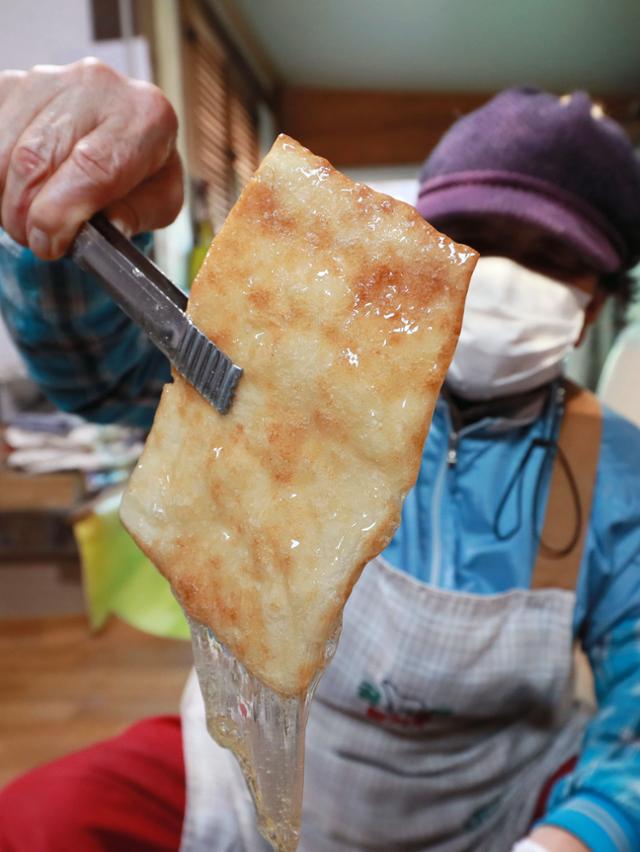 개평마을 할머니가 자갈에 구운 반대기에 조청을 바르고 있다. 함양군 제공