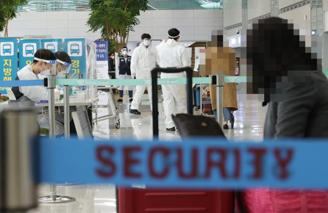 30일 오후 인천국제공항 제2여객터미널 입국장에서 일본 오사카발 항공편 해외입국자들이 방역 관계자들의 안내를 받고 있다. 연합뉴스