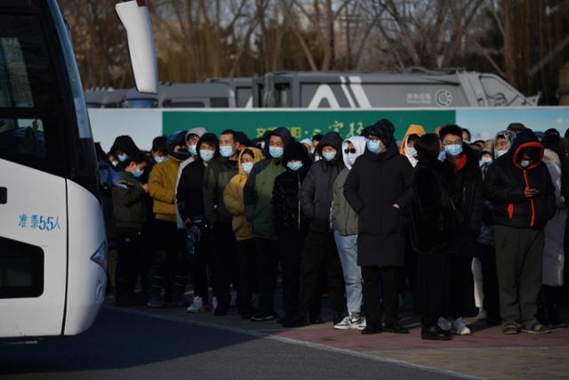 중국 베이징에서 4일 코로나19 백신 접종소까지 운행하는 셔틀버스 앞에 시민들이 줄지어 서 있다. 베이징=AFP 연합뉴스