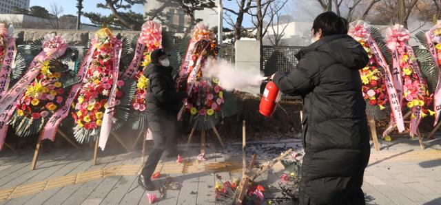 5일 오전 서울 서초구 대검찰청 앞에서 한 남성이 윤석열 검찰총장 응원화환에 불을 붙이자 대검 보안요원들이 달려와 불을 끄고 있다. 연합뉴스