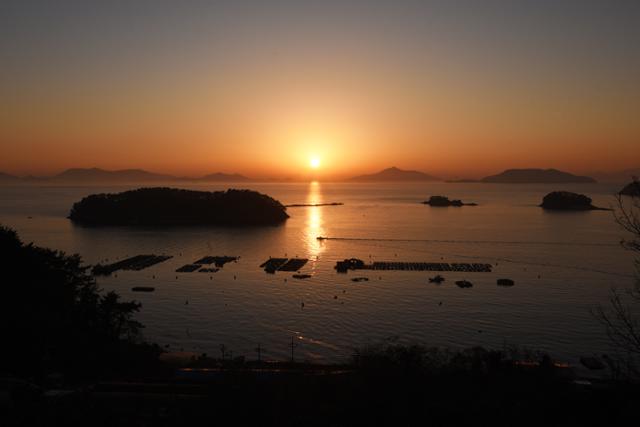 달아공원 부근 산양일주도로에서 보는 일몰 풍경. 섬과 양식장 어선이 어우러져 풍성한 노을이다.