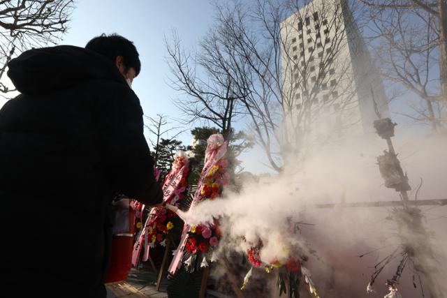 5일 오전 서울 서초구 대검찰청 앞에서 한 남성이 윤석열 검찰총장 응원화환에 불을 붙이자 대검 보안요원들이 달려와 불을 끄고 있다. 연합뉴스