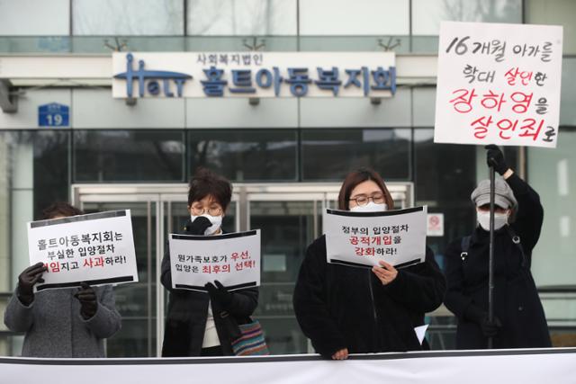 지난달 23일 서울 마포구 홀트아동복지회 앞에서 열린 홀트아동복지회에 부실한 입양절차에 대한 사과를 요구하는 집회에서 참석자들이 손팻말을 들고 있다. 연합뉴스