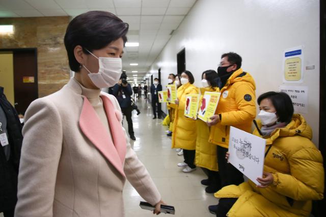 백혜련(왼쪽) 국회 법제사법위원회 법안심사제1소위원회 위원장이 7일 국회에서 "더불어민주당과 국민의힘이 중대재해기업처벌법을 후퇴시켰다"며 피켓 시위를 하는 정의당 의원들 앞을 지나치고 있다. 오대근 기자