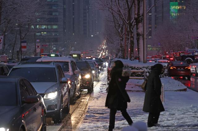 기상청 예보와 달리 함박눈이 내린 12일 오후 서울 강남구에서 한 시민이 교통대란을 피해 지하철역으로 향하고 있다. 연합뉴스