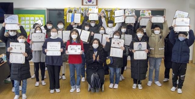 12일 오전 광주 서구 광천초등학교 6학년 교실에서 졸업식이 열린 가운데 교사와 제자들이 졸업장을 펼쳐보이며 기념사진을 찍고 있다. 광주=뉴시스