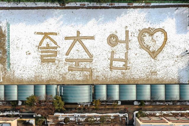 13일 비대면 온라인 졸업식이 열린 서울 노원구 태랑초등학교 운동장 눈밭에 학생들의 졸업을 축하는 문구가 쓰여 있다. 이한호 기자