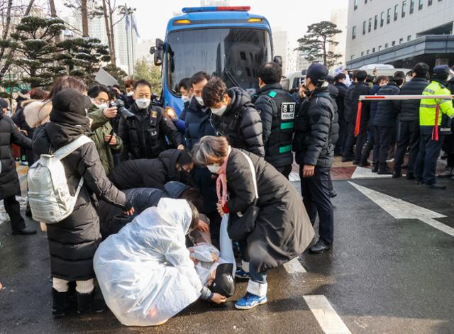 16개월 된 입양 딸 정인이를 학대해 숨지게 한 혐의를 받고 있는 양부모에 대한 첫 공판이 열린 13일 오전 서울 양천구 남부지방법원에서 양모 장씨가 탄 호송차량이 법원을 나서자, 한 시민이 분노하며 바닥에 누워 살인죄 처벌을 요구하고 있다. 고영권 기자