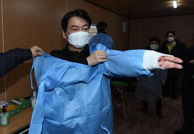 안철수 국민의당 대표가 15일 오전 서울 중구 서울시청 앞에 마련된 코로나19 임시 선별검사소에서 의료자원봉사에 앞서 방호복으로 환복하고 있다. 국회사진기자단