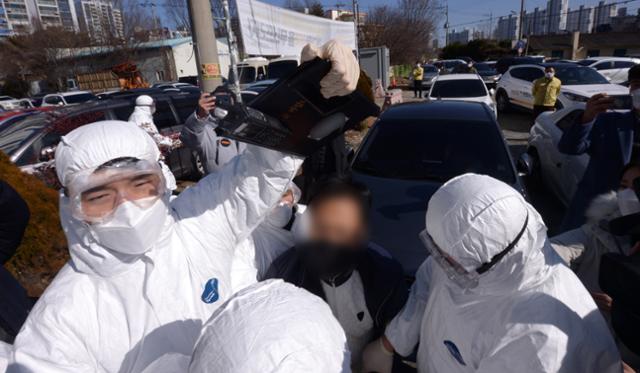 27일 오후 광주 광산구 TCS국제학교 앞에서 한 시민이 건물 외벽에 계란을 던지려다 경찰의 제지를 받고 있다. 뉴스1