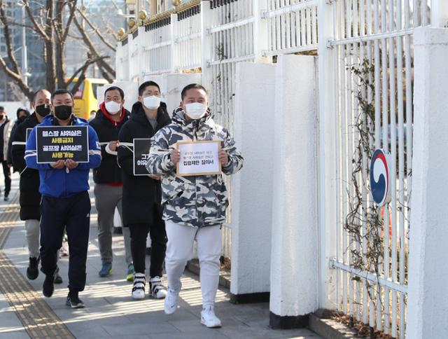 대한피트니스경영자협회 등 실내체육시설 업주들이 27일 서울 종로구 세종대로 정부서울청사 앞에서 정부의 방역지침 기준에 반발하는 기자회견을 마친 뒤 관련 질의서 전달을 위해 민원실로 향하고 있다. 이들은 영업 제한 등 방역조치가 업종별 형평성이나 현실에 맞지 않는다고 지적하며, 방역 당국에 정식 면담을 요청했다. 연합뉴스