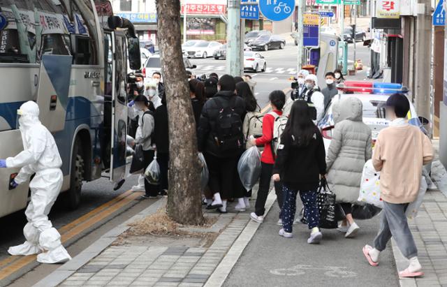 종교단체가 설립한 전국 비인가 교육시설의 코로나19 집단감염 발원지로 지목되고 있는 대전 중구 IEM국제학교 학생과 교직원 등이 25일 생활치료센터로 이동하기 위해 차량에 오르고 있다. 뉴스1