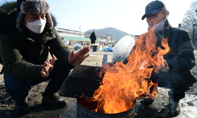 지난달 29일 전북 전주시 전주남부시장에서 시민들이 모닥불을 쬐며 추위를 달래고 있다. 뉴시스