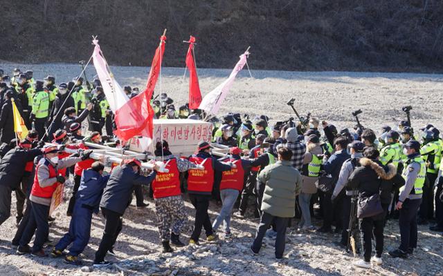 경북 포항 남구 장기면 주민들이 4일 수성사격장 앞 하천에서 주한미군 아파치헬기 사격훈련에 항의하며 국방부장관과 한미연합사령관이라는 직책이 적힌 나무 관을 들고 경찰과 대치하고 있다. 포항=김정혜기자 kjh@hankookilbo.com