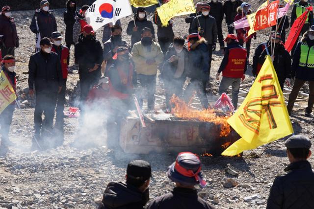 경북 포항 남구 장기면 주민들이 4일 수성사격장 앞 하천에서 주한미군 아파치헬기 사격훈련에 반발, 국방부장관과 한미연합사령관 직책을 쓴 나무 관을 태우고 있다. 포항=김정혜기자 kjh@hankookilbo.com