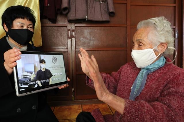 설을 맞아 경북 의성군에 거주하는 한 어르신이 타지에 나가있는 자녀들이 보낸 영상편지를 보고 인사를 하고 있다. 의성군 제공