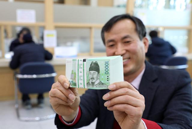 지난달 21일 오후 광주 서구 한국은행 광주전남본부에서 한 시민이 만원권 지폐를 신권으로 교환한 모습. 광주=연합뉴스.