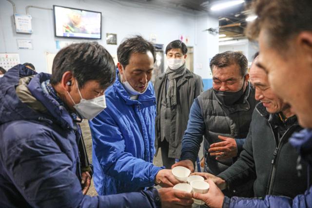 우상호 더불어민주당 서울시장 예비후보가 6일 오전 서울 가락농수산물종합시장을 찾아 상인들과 소주가 든 종이컵을 맞대고 있다. 우상호 의원실 제공