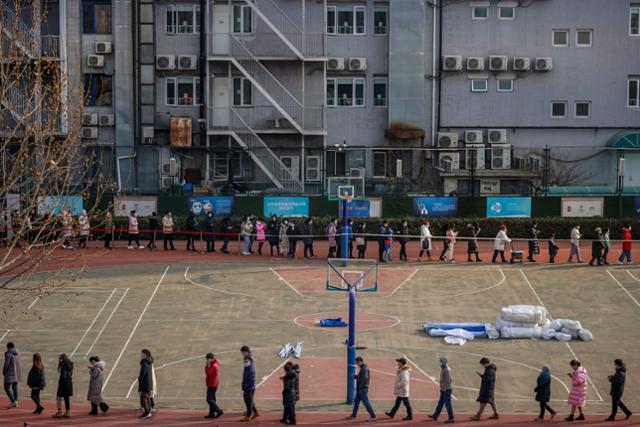 중국 베이징의 한 학교 운동장에서 주민들이 코로나19 핵산 검사를 받기 위해 줄지어 기다리고 있다. 베이징=로이터 연합뉴스