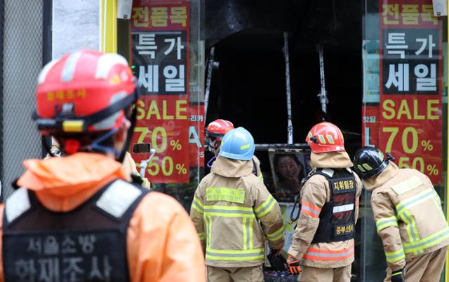 설 연휴 마지막날인 14일 서울 중구 명동거리의 한 화장품 매장에서 화재가 발생해 소방당국과 경찰 관계자들이 현장을 살펴보고 있다. 이날 오전 4시55분께 발생한 화재는 8시13분께 진화됐다. 뉴시스