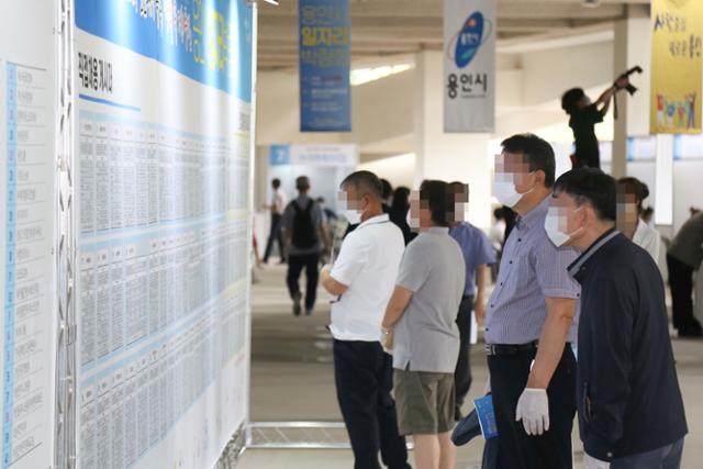 지난해 경기 용인시에서 열린 생활속 거리두기 일자리박람회에 참가한 구직자들이 벽에 붙은 구인현황을 바라보고 있다. 용인시 제공