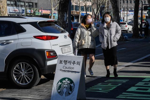 지난 8일, 서울 송파구의 한 스타벅스 DT점, 매장에서 나가는 차량 뒤로 시민들이 지나가고 있다.