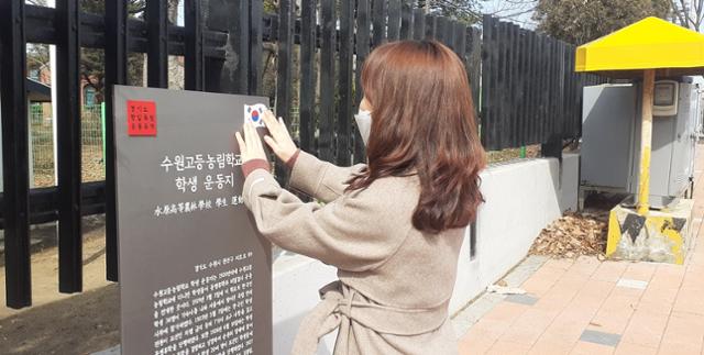 경기도청 직원이 항일유적지 중 하나인 수원고등농림학교 앞에 항일유적지임을 알리는 안내판의 태극기를 만지고 있다. 경기도 제공