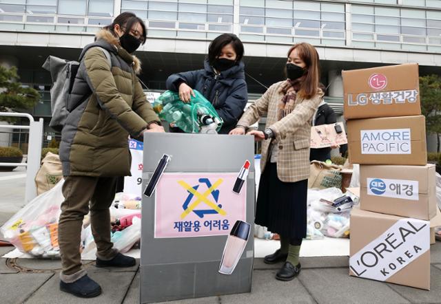 25일 오전 서울 종로구 LG광화문빌딩 앞에서 열린 '화장품 용기 재활용 문제 개선 촉구' 기자회견에서 참여자들이 수거한 화장품 용기를 '재활용 어려움'이 적힌 박스에 쏟아 붓는 퍼포먼스를 하고 있다. 연합뉴스