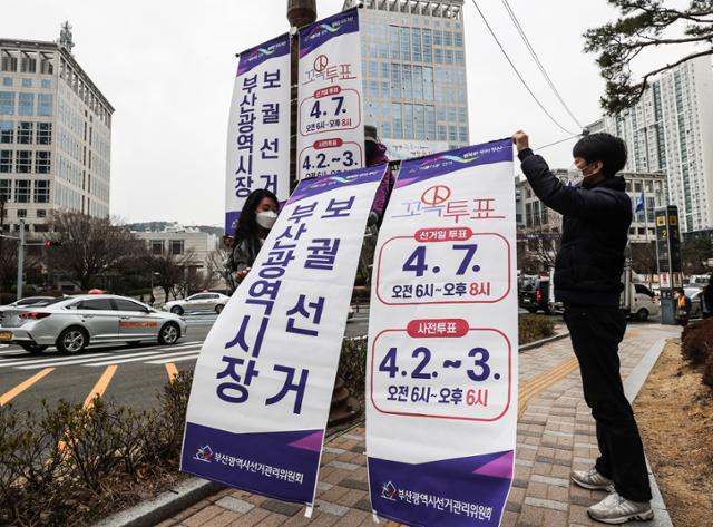 25일 부산시 연제구 도시철도 시청역 앞 가로등에 부산시선거관리위원회 직원들이 4월 7일 부산시장 보궐선거를 알리는 현수기를 내걸고 있다. 부산=연합뉴스